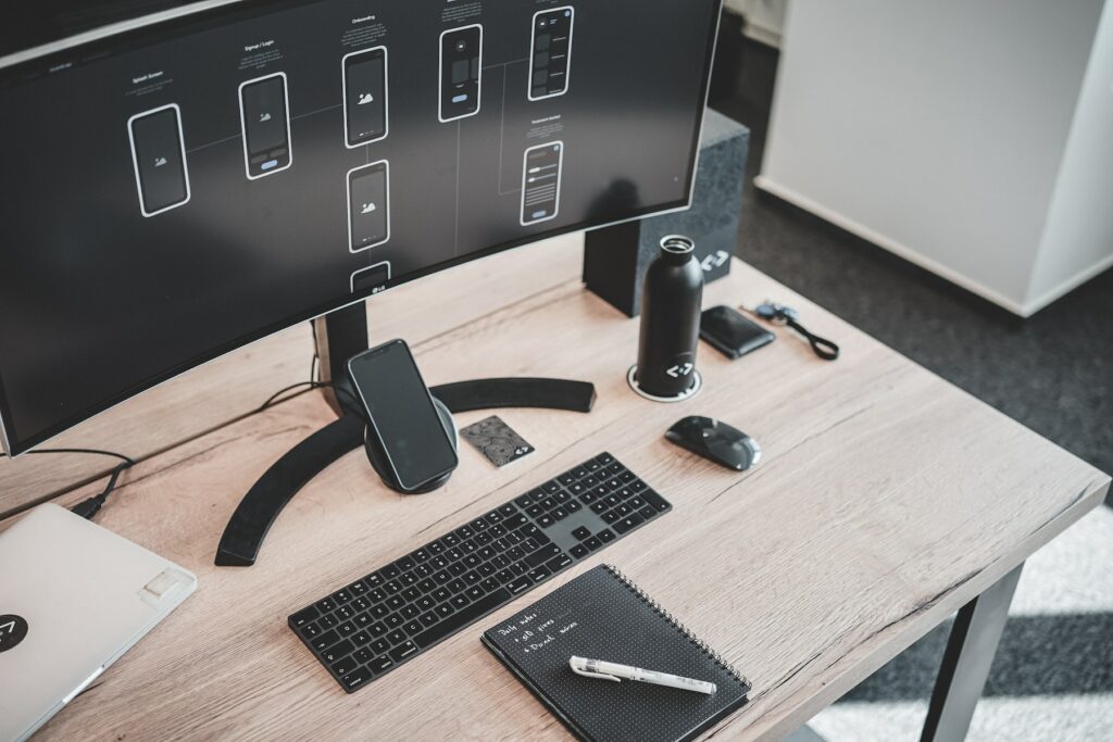 Computer, Handy und Notizblock in Schwarz