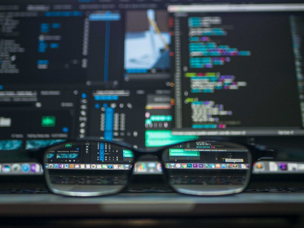Computer mit Codes und davor eine Brille
