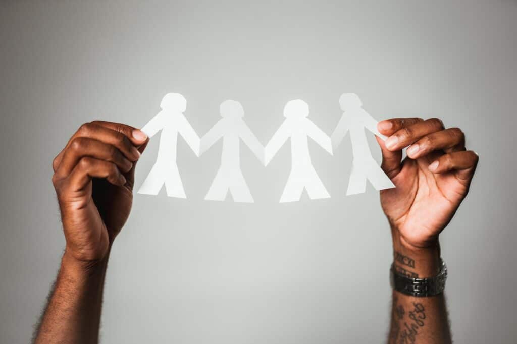 Hände halten eine Auschnitt aus Papier von Personen in der Hand